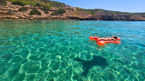 Ragazza fa il bagno con materassino nel Golfo di Alghero