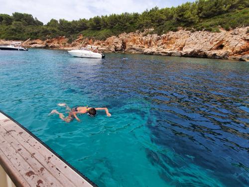 Ragazzo fa il bagno nel Golfo di Alghero durante escursione in barca