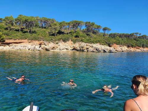 Boys do snorkelling in the Gulf of Alghero during boat excursion