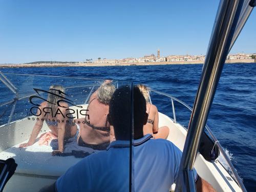 Barca in navigazione a largo della città di Alghero
