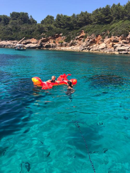 Jungen schwimmen mit Matratze im Golf von Alghero