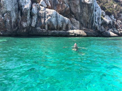 Person takes a bath in the coast of Alghero