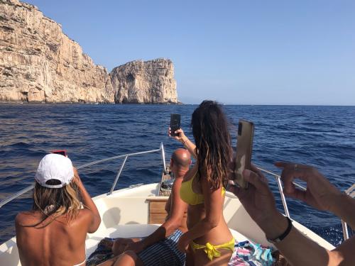 Jungen machen Fotos vom Boot aus während einer Tour im Golf von Alghero
