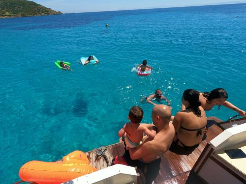 Familienbaden im Golf von Asinara bei einem Ausflug mit einem hölzernen Gozzo