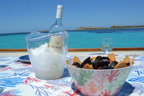 White wine in ice and bowl of mussels on board a wooden gozzo in the Gulf of Asinara