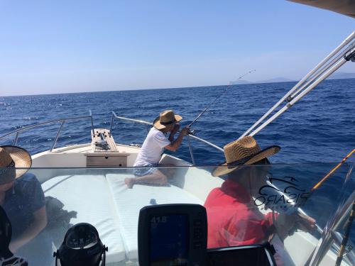 Wanderer versuchen sich bei einem Ausflug in den Golf von Alghero im Angeln vom Boot aus