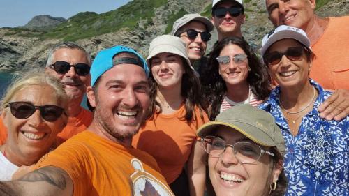 El guía se hace una foto de recuerdo con los participantes durante una excursión de snorkel entre las playas salvajes del Nurra