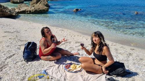 Zwei Mädchen machen die Verkostung am Strand von Nurra während der Schnorcheltour