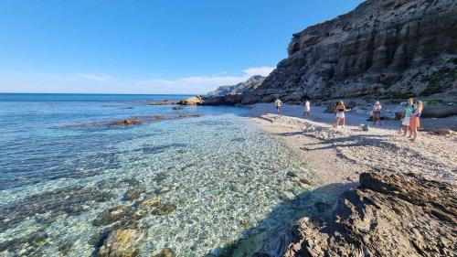 Partecipanti su una spiaggia selvaggia nel nord-ovest della Sardegna