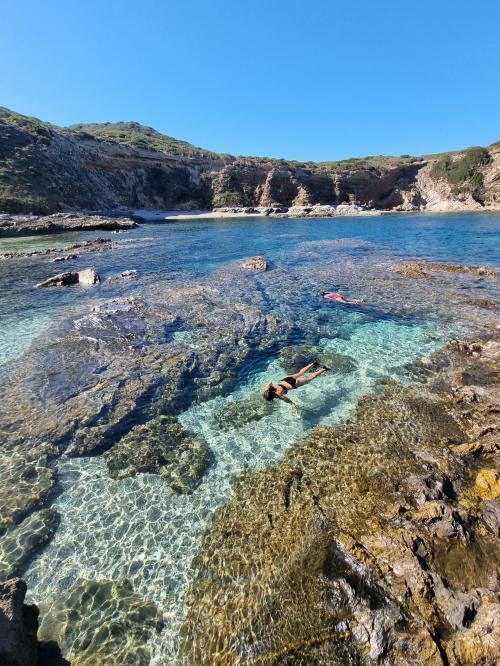 Escursionisti fanno snorkeling guidato nelle spiagge selvagge del nord ovest Sardegna
