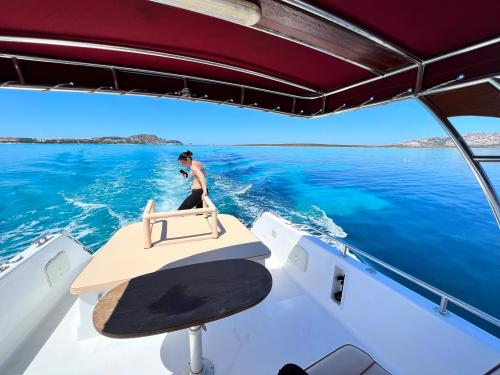 <p>Motor boat sails in the crystal clear waters in front of La Pelosa</p><p><br></p>