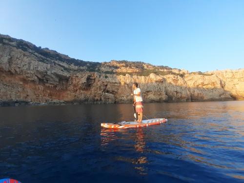 <p>Junge im SUP im Meer von Alghero bei Sonnenuntergang</p><p><br></p>