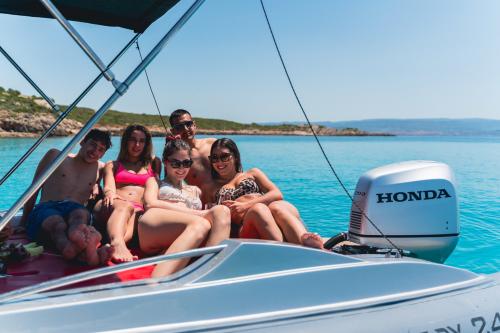 Chicos tumbados en una lancha en la costa de Alghero