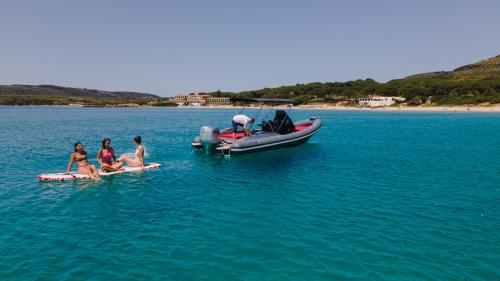 Ragazze sopra SUP durante escursione in gommone ad Alghero