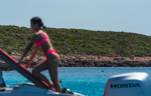 Chica en una lancha neumática en el Golfo de Alghero