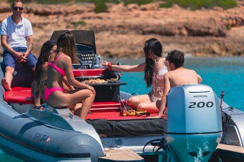 Jungen an Bord eines Schlauchbootes an der Küste von Alghero