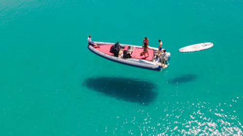 Schlauchboot mit SUP während einer Tour im Golf von Alghero