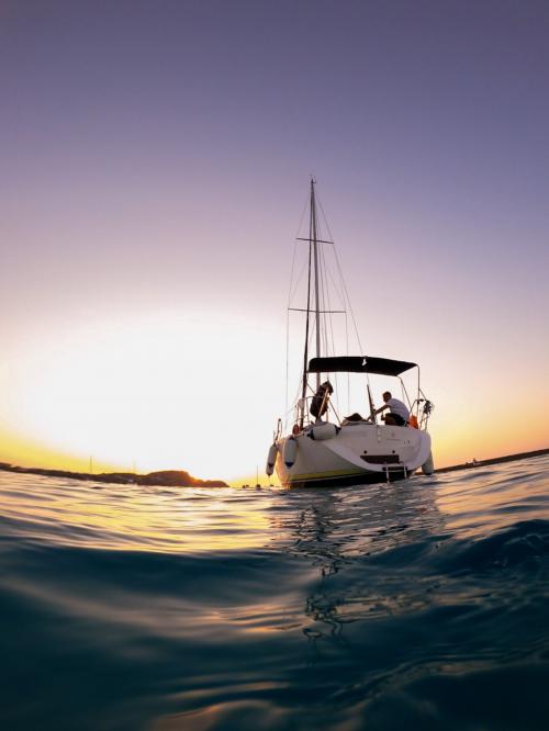Barca a vela nel Golfo dell'Asinara tra i colori del tramonto