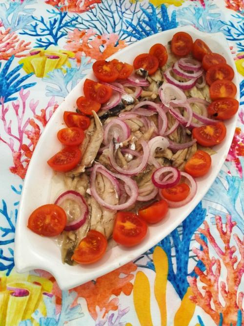 Dish of anchovies with onions and tomato on a boat in Asinara