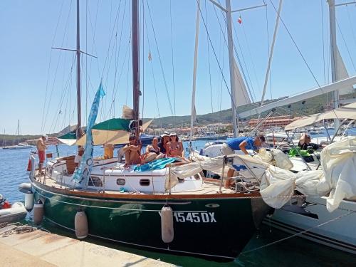 Barca a vela in porto a Palau con passeggeri a bordo prima di partenza escursione