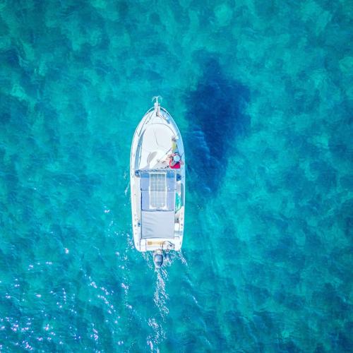 Foto drone barca nelle acque cristalline del Golfo dell'Asinara