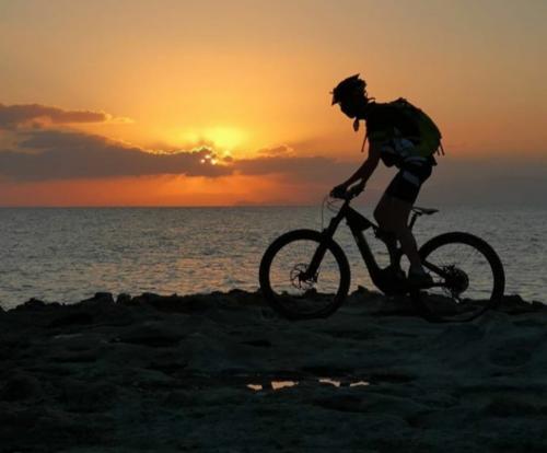 Tramonto sul mare del nord Sardegna con ciclista