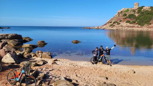 Escursionisti in MTB lungo la costa di Alghero con vista panoramica sul mare
