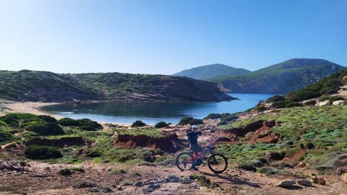 MTB-Wanderer entlang der Küste von Alghero mit Panoramablick aufs Meer