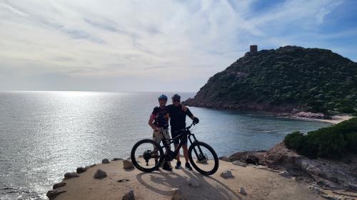 MTB-Wanderer entlang der Küste von Alghero mit Panoramablick aufs Meer