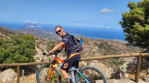 escursionista in bicicletta elettrica con vista panoramica sulla costa di San Teodoro