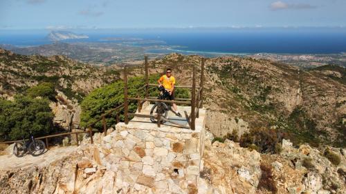 escursionista in bicicletta elettrica con vista panoramica sulla costa di San Teodoro