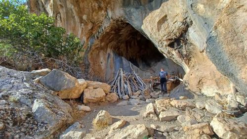 Hikers explore a cave on the trail to Gorropu canyon