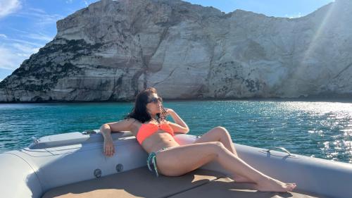 Mädchen liegt im Bug eines Beiboots im Golf von Cagliari