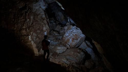 Wanderer wandert in der dunklen Höhle Sa Nurre de Su Hoda in Oliena
