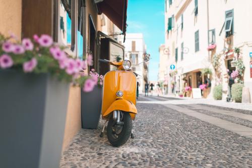 <p>Typisches italienisches Motorrad namens Vespa in einer Straße im historischen Zentrum von Alghero</p><p><br></p>