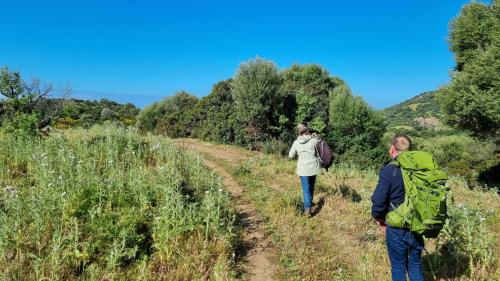 Two hikers walk a nature trail during a trek in Capo Marrargiu