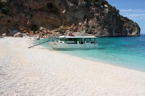 Fishing boat moors in Cala Luna during fishing day