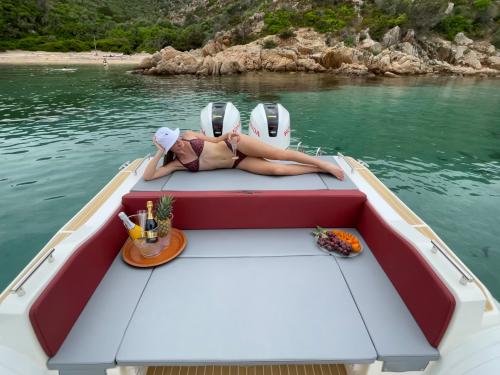 Chica a bordo de un bote durante el tour en el Archipiélago de La Maddalena y Caprera con aperitivo servido a bordo