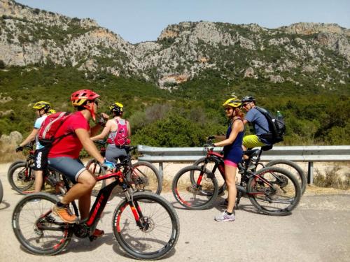 hikers on electric bikes in the Sardinian inland mountains between Dorgali Orosei Baunei on the east coast of the island