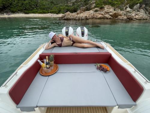 Ragazza a bordo di un gommone nel mare della Corsica con aperitivo a bordo