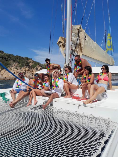Jungen und Mädchen entspannen sich an Bord eines Katamarans im Archipel von La Maddalena