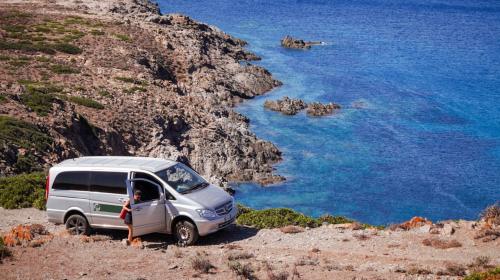 Van on the dirt roads of the Asinara Park island with crystal blue sea