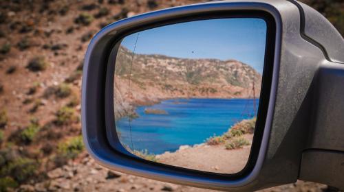 Van on the dirt roads of the Asinara Park island with crystal blue sea