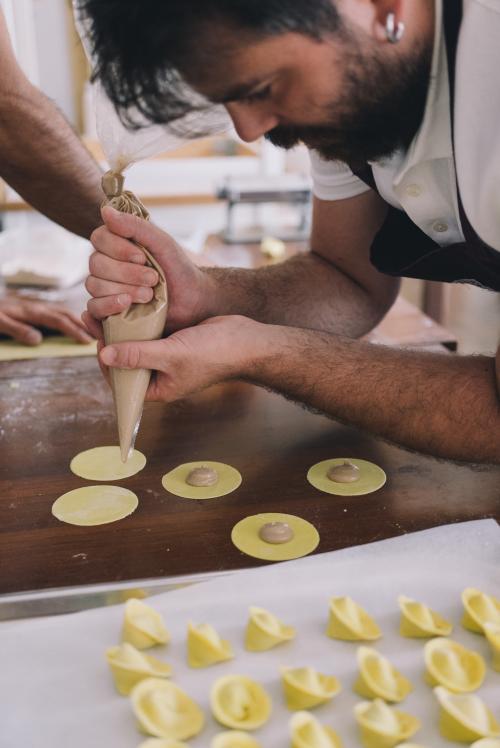 Guida dimostra la preparazione della pasta sarda fatta a mano durante laboratorio ad Olbia in ristorante