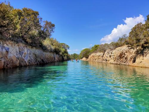 Crystal clear waters inside the oasis of Biderosa and kayak hikers during guided tours