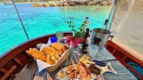 <p>Abundante almuerzo con productos locales a bordo de un barco en el Archipiélago de La Maddalena</p><p><br></p>