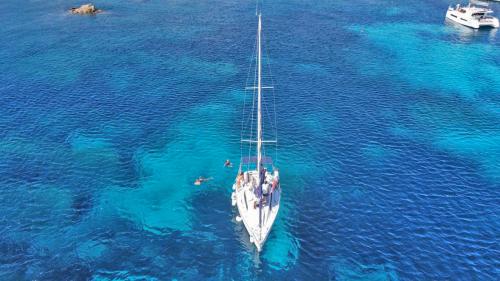 Sailing boat in the crystal clear waters of Asinara National Park Stintino