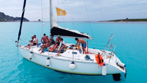 Barca a vela Equinoxe con passeggeri a bordo nelle acque de La Pelosa