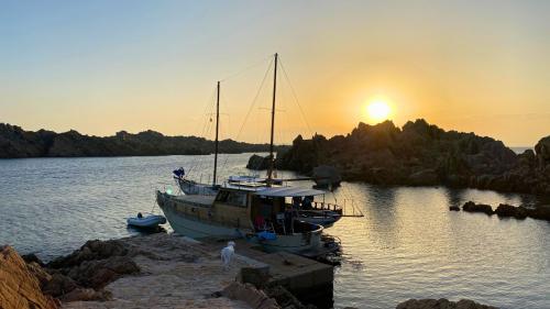 Sonnenuntergangspanorama während einer Holzbootfahrt auf der Insel Caprera in La Maddalena