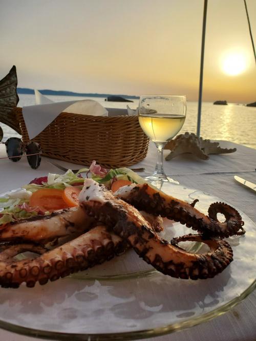 Cena a base di pesce con vista mare a bordo di una barca